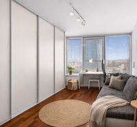 A room in a 3-room apartment with a comfortable sofa, a table, and a floor with a wooden decor.