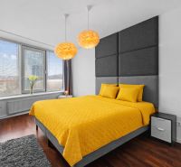 A bedroom in a 3-room apartment with a bed and yellow bedding, a floor with a wooden decor.