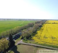 Yellow fields and green meadows near the railway track in Palárikovo. Residential plots.