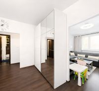 Interior of a 4-room apartment with a wooden decor floor, a sofa, and a children's table.