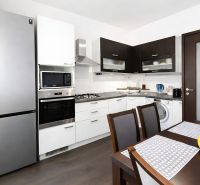 A kitchen in a 4-room apartment with a wooden decor floor and modern appliances.