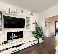 Living room with a wall cabinet and a television, floor with wooden decor, 4-room apartment.