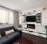 Living room with a sofa, television, and wooden decor flooring in a 4-room apartment.