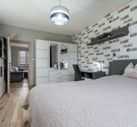 Bedroom in a 2-room apartment with a wooden decor floor and modern furniture.