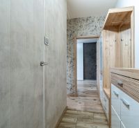 A hallway with furniture and flooring with a wooden decor in a 2-room apartment.