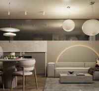 Interior of a holiday apartment with a wooden decor floor, a comfortable sofa, and a dining table.