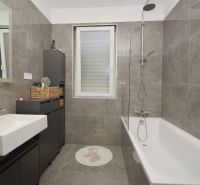 Bathroom with a bathtub and a sink, neutral decor, family house.