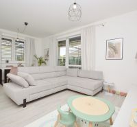 Living room in a family house with a wooden decor floor and a gray sofa.