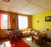 The interior of the cottage with light wooden decor, cozy seating, and retro tiles.