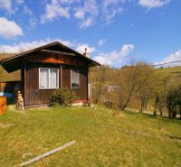 A wooden cabin surrounded by greenery on a plot in Krásno nad Kysucou, suitable for living.