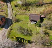 A cottage in Krásno nad Kysucou surrounded by greenery with trees and a garden.