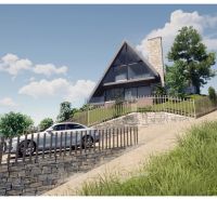 A cottage in Podhradí with a stone fence on a slope among trees and a blue sky.