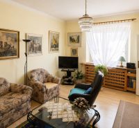 Living room in a family house with floral patterns and a wooden decor floor.