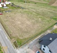Plots - housing in the village of Vlková, showing an open grassy area bordered by a road and houses.