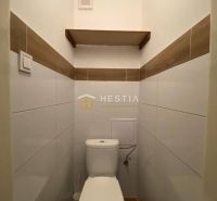 Bathroom in a 2-room apartment with practical white toilet and wooden decor.