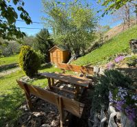 A garden at a family house in Čaradice, a wooden gazebo with a table and benches surrounded by nature.