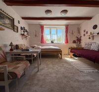 Living room in a family house with sofas, a window, and decorations on the wall.