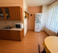 A kitchen in a 3-room apartment with a wood-patterned floor and a dining area.