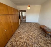 A room with a carpet, wooden cabinets, and a table, a 3-room apartment.