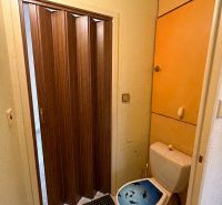 A toilet with folding doors in a 3-room apartment.