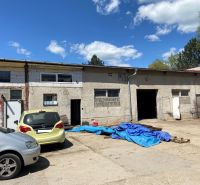 The courtyard of special properties on Košická Road in Rimavská Sobota with cars and tarpaulins.
