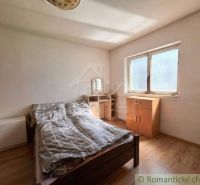 Bedroom in a family house with a bed and furniture, floor with wooden decor.