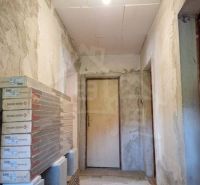 A hallway in a family house with unfinished walls and doors, prepared packages of laminate.