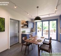 A kitchen in a family house with blue cabinets and access to the terrace.
