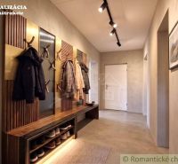Entrance hall in a family house with coat racks, a bench, and lighting.