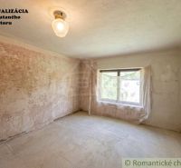 A parched room in a family house with unfinished walls and one window.