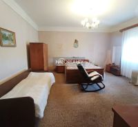 A bedroom in a 2-room apartment with a carpet, bed, chair, and wardrobes.