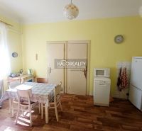 A kitchen in a 2-room apartment with a wooden decor floor and a dining table.