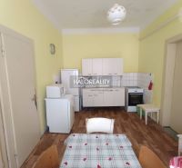 A kitchen in a 2-room apartment with a wooden decor floor and basic appliances.