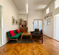 Offices with a sofa and chairs, floor with wood decor, walls with decorations.