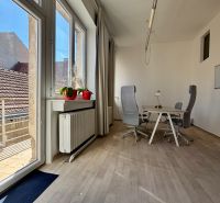 Offices with wood-patterned flooring, a table, and chairs by the windows.
