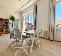 Offices with large windows, a desk and chairs, and a floor with a wooden decor.