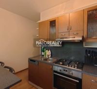 A kitchen in a 2-room apartment with a wooden decor floor and a kitchen unit.