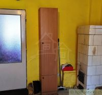 Yellow wall with a tiled stove, door, and wardrobe in a family house.