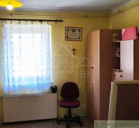 A room in a family house with furniture, a window, and a wooden decor floor.