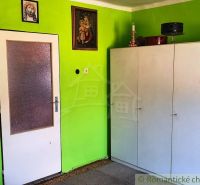 Interior of a family house with a white cabinet and a green wall with icons.