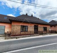 A family house in Reľov with brick cladding and a sloped metal roof.
