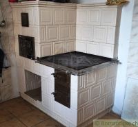 Traditional solid fuel stove in a family house with tiles and cladding.