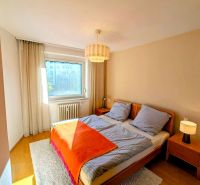 A bright bedroom in a 4-room apartment with a double bed and a wooden decor floor.