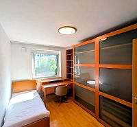 A room with furniture, a bed, a table, a wardrobe, and a floor with a wooden decor in a 4-room apartment.