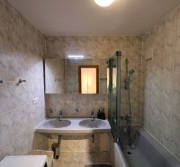 A bathroom with a bathtub and two sinks in a 4-room apartment with a washing machine.