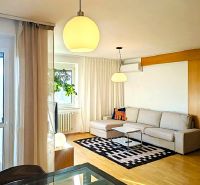 Living room in a 4-room apartment with a wooden decor floor and comfortable seating.