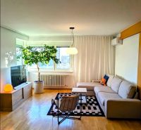 Living room in a 4-room apartment with a corner sofa and a floor with a wooden decor.
