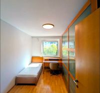 A room in a 4-room apartment with a bed, a table, and a floor with a wooden decor.