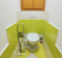 A bathroom with colorful tiles and a wooden cabinet in a two-room apartment.
