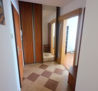 Hallway of a 2-room apartment with tiles, built-in wardrobes, and a mirror.